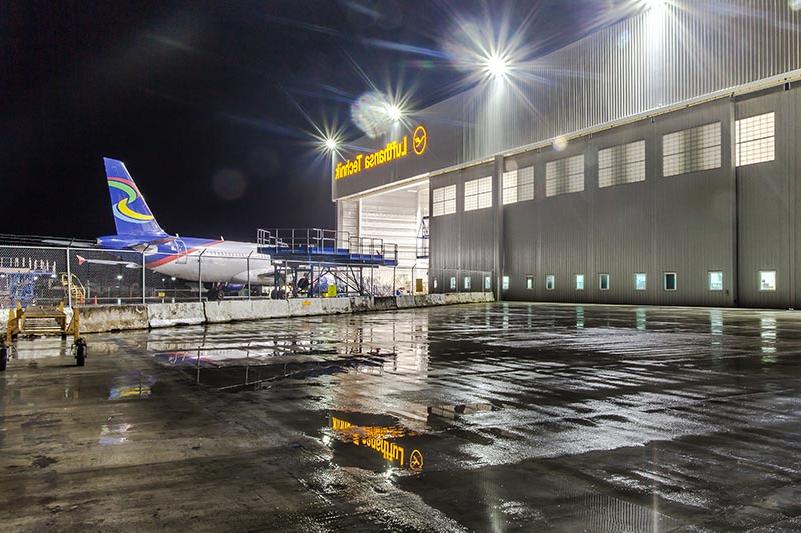 汉莎航空技术公司重型维修设施外的夜晚. 飞机从后面进入机库.